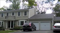 a house with two cars parked in front of it
